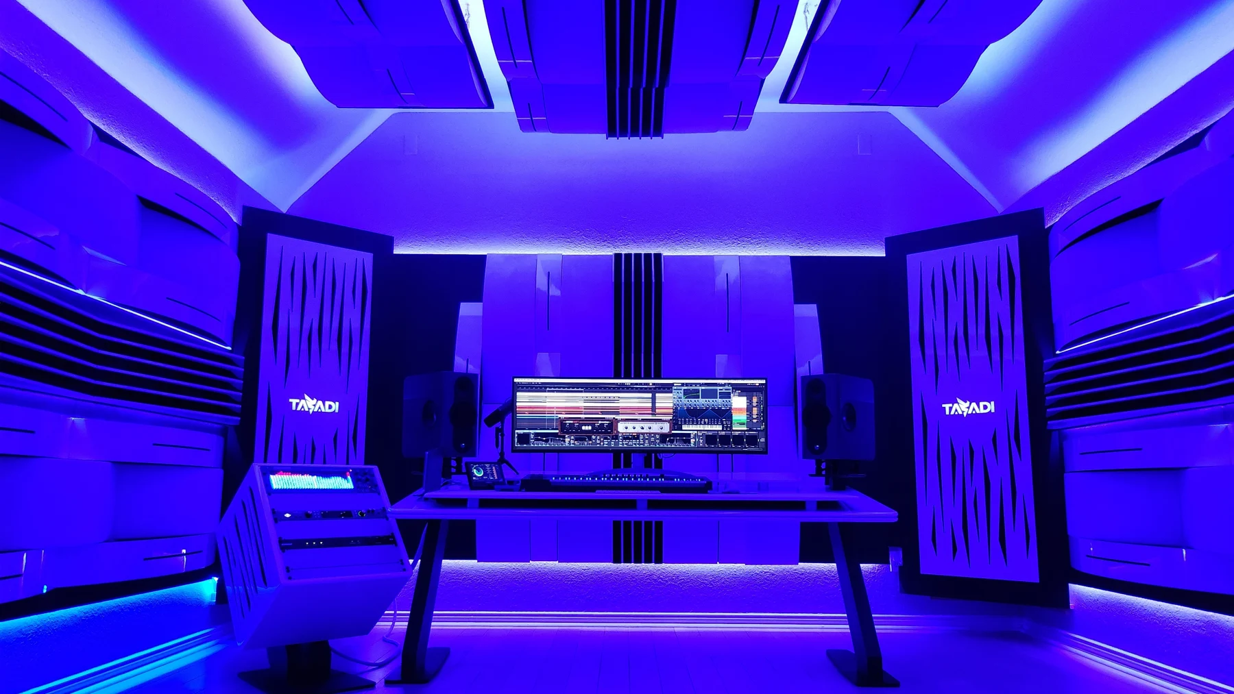 TASADI studio with violet lighting, monitors and synthesizers